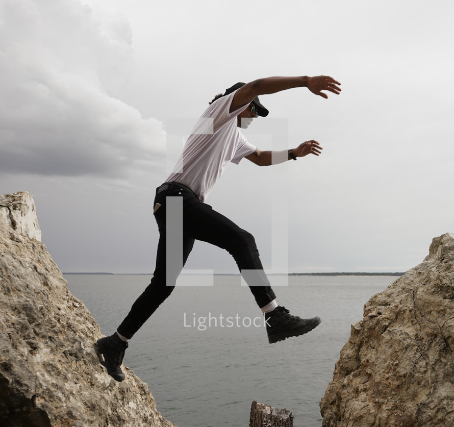 a man leaping between rocks 