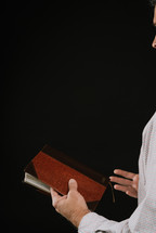 man preaching holding a Bible 