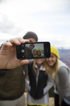 friends taking a selfie on a mountaintop