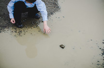 boy playing in a puddle 