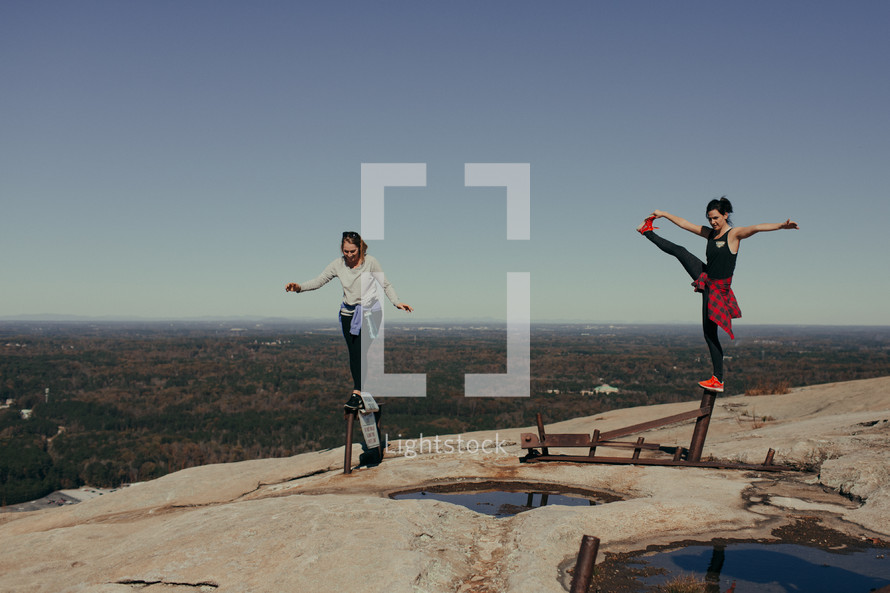 women balancing on pipes on a mountaintop