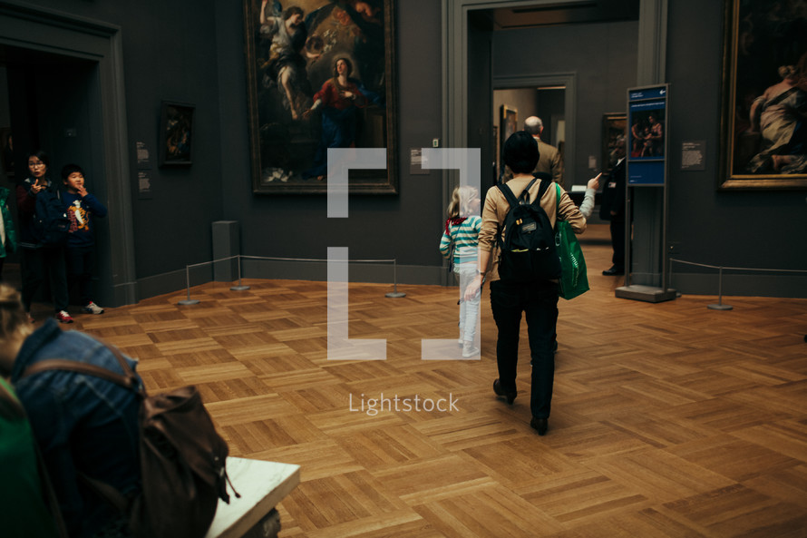 people walking through an art museum 