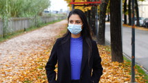 a young woman wearing a face mask outdoors 