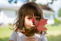 girl holding fall leaves 