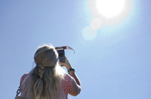 woman taking a picture of the solar eclipse 