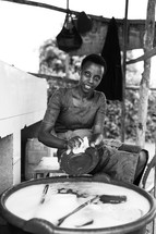 a woman washing dishing in a bucket of clean water 