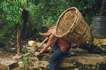 a boy gathering crops with a basket on his back 