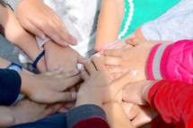 kids with stacked hands for teamwork 