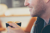 a man holding a mug of coffee 