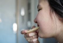 Girl eating slice of the gluten free crisp bread