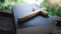 wooden cross on a Bible in a window 