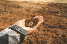 Title: Handful of arable soil in hands of responsible farmer, close up.