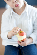 Little boy eating an apple 