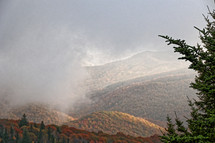 fog and clouds moving over a mountain scene 