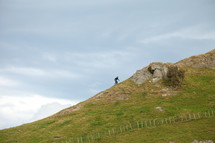 man climbing up a mountain peak 