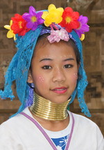 Woman wearing a floral headdress and brass neck rings
