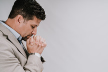 a man with head bowed praying 