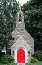 red doors to a stone church 