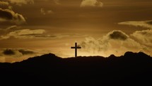 Crucifix on mountain top at sunset