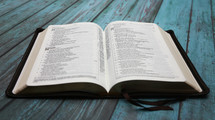 open Bible on blue wood boards 