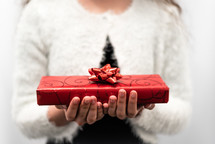 a woman holding a wrapped Christmas present 