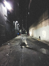 puddle of water in an alley at night 