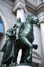 Bronze statue of a man on a horse with a native American Indian by his side.