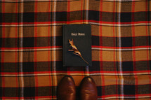 Bible on a plaid blanket and boots 