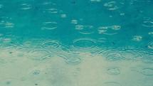 rain droplets on the surface of pool water 