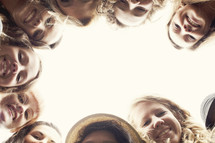 a group of happy teenage girl's heads looking down at the camera