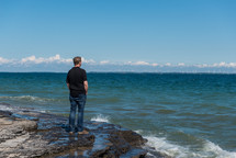 man standing on a rocky shore