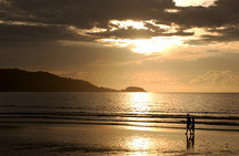 couple walking on a beach at sunset 