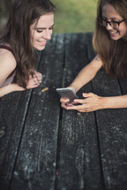 teen girls looking at a cellphone screen 