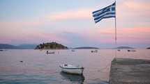 boat tied to a shore and Greek Flag 