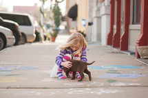 girl child playing with a puppy 