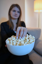 a woman eating a snack of popcorn 