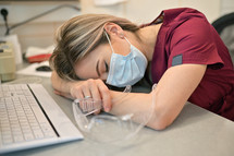 Young Doctor Sleeping On The Desk In Medical Office
