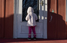 a child standing in front of a door 