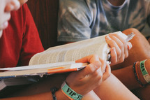 teen boy reading a Bible at a Bible study 