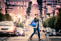 woman with a purse crossing a busy street 