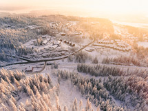 aerial view over a mountain town covered in snow 