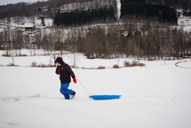 a boy pulling a sled 