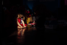 sunlight on a little girl in a dark room 