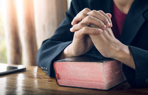 praying hands on a Bible 