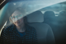 a woman sitting in the passengers seat of a car 