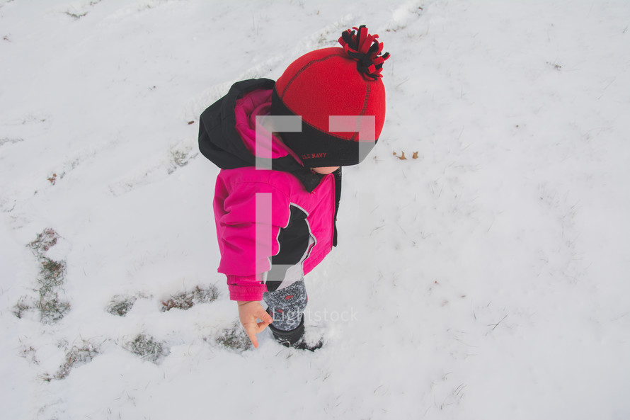 A toddler walking in snow