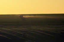 farming Tractor Plowing And Spraying On Spring Field