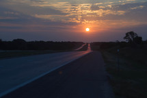 sun setting over a highway 