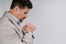 a man in a suit praying 