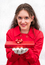 a woman in a red coat holding a wrapped Christmas gift 